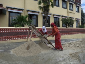 Women shoveling sand at the Monastery